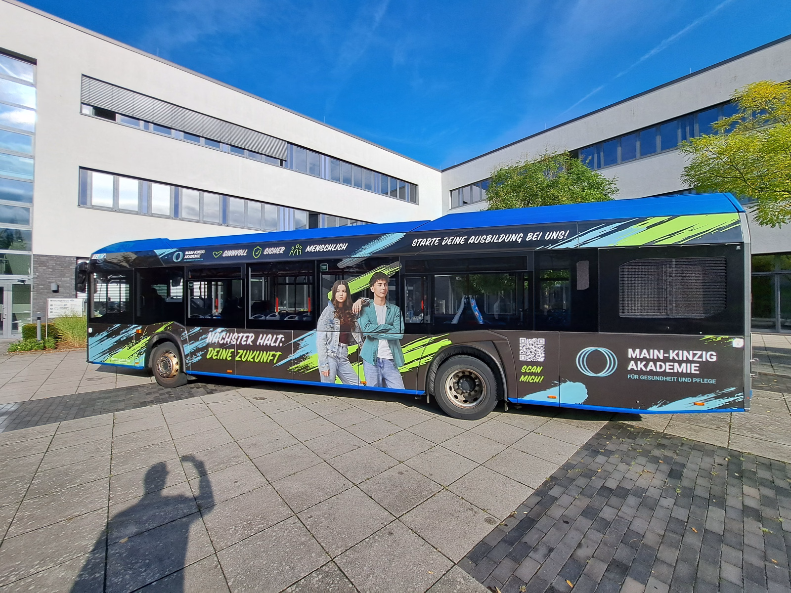 Seitenansicht eines blauen Werbebusses der Main-Kinzig Akademie