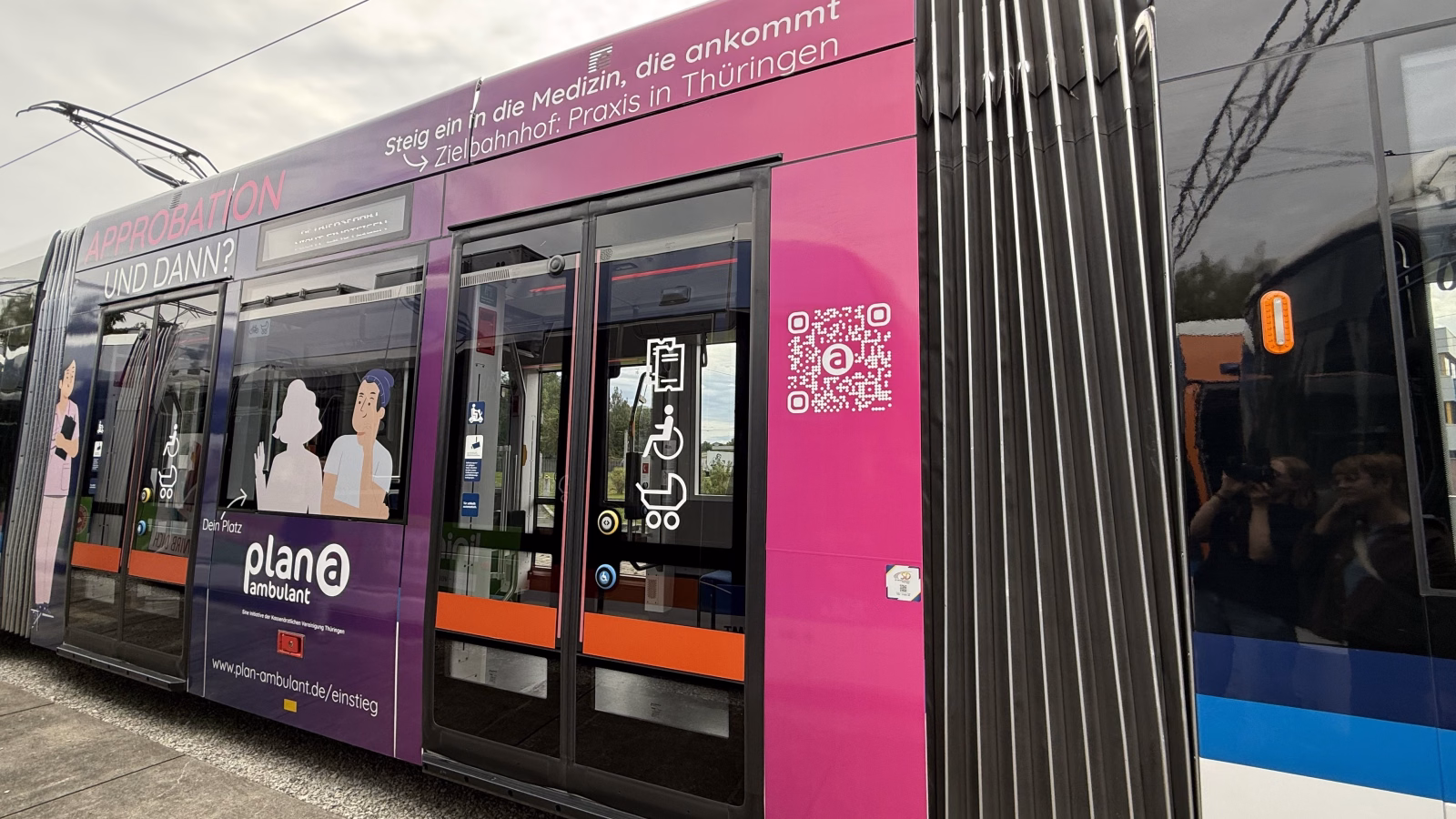 Seitenansicht einer pinken Straßenbahn der kassenärtzlichen Vereinigung