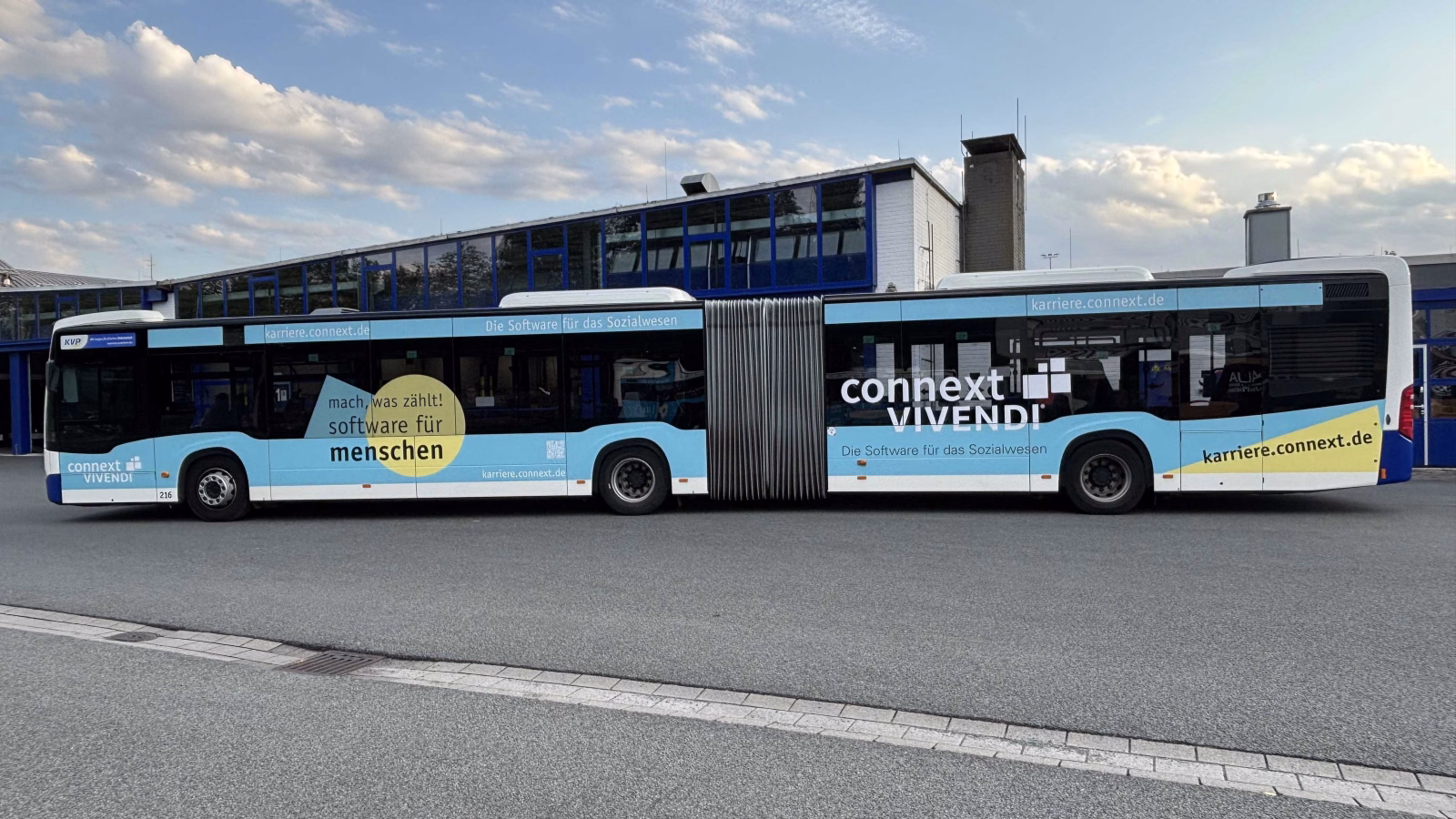 Außenseite eines blauen Gelenkbusses mit Werbung der Connext Vivendi