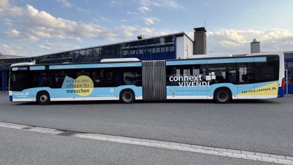 Außenseite eines blauen Gelenkbusses mit Werbung der Connext Vivendi