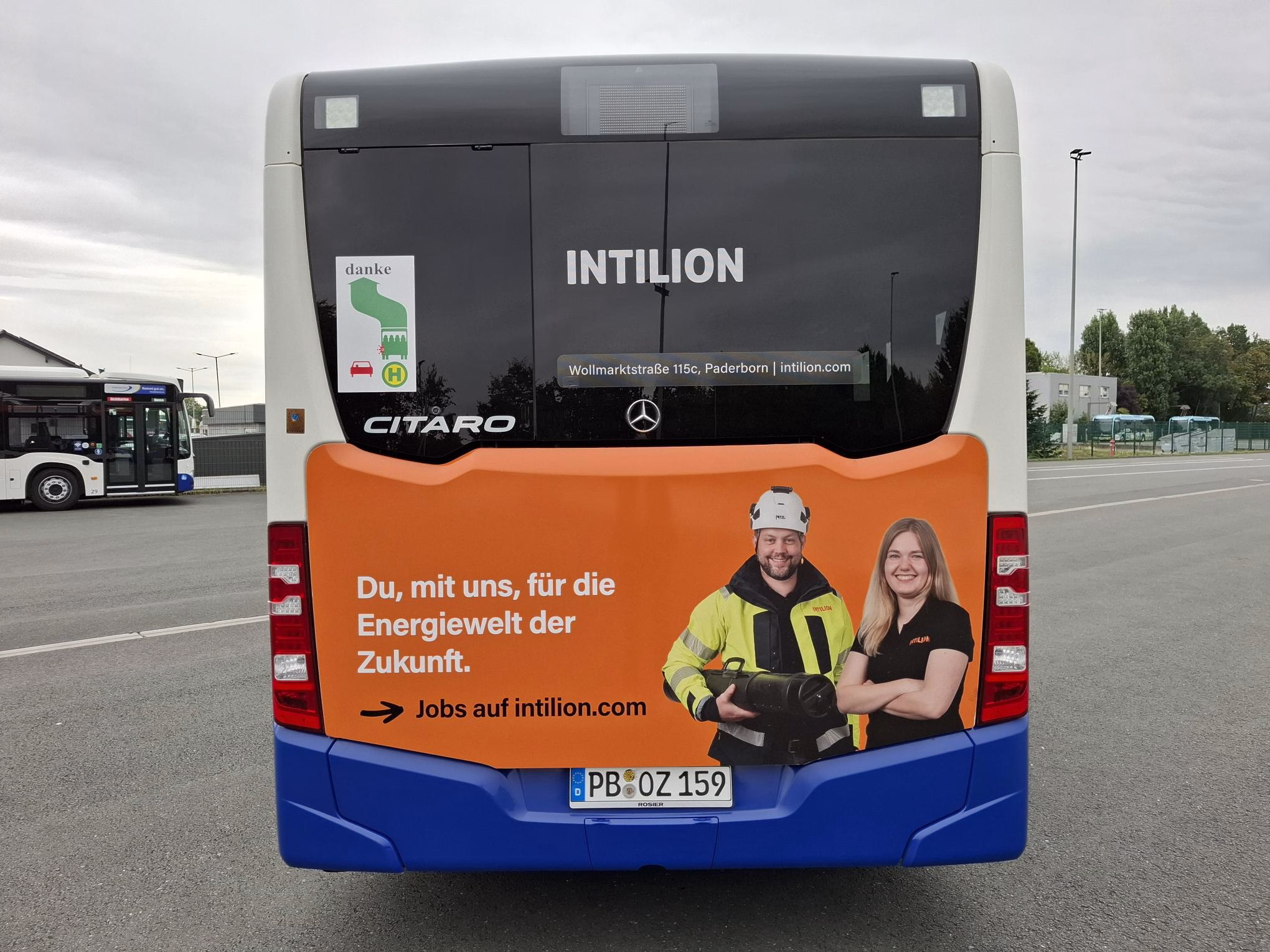 Heckansicht eines orangen Busses mit Werbung von PaderSprinter