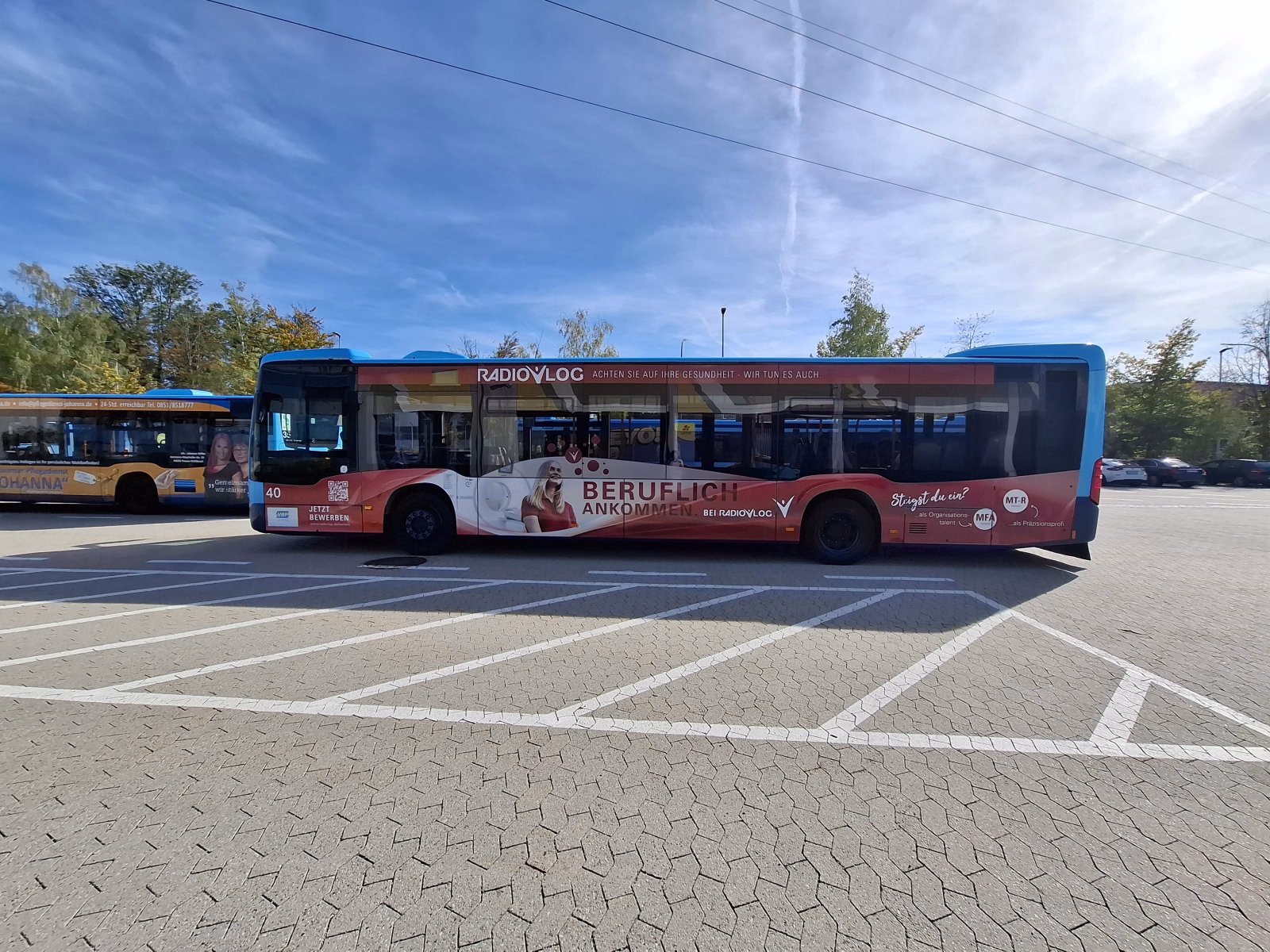 Außenseite eines roten Stadtbusses mit Werbung von Radiolog